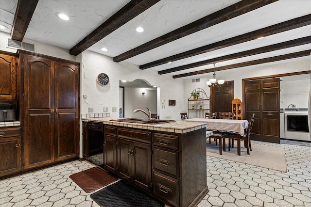 N84W16033 Menomonee Ave Unit 200, Menomonee Falls, WI 53051 - kitchen with dishwasher, beam ceiling, a peninsula, tile counters, and a chandelier