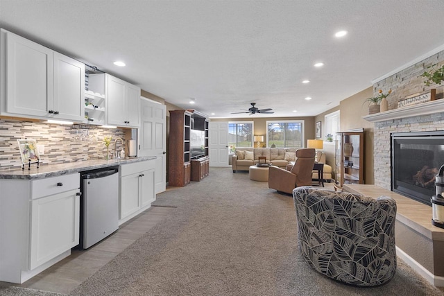 living room featuring a fireplace, ceiling fan, a textured ceiling, and recessed lighting