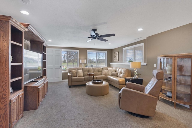 living room with a ceiling fan, a textured ceiling, recessed lighting, and light colored carpet