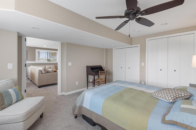 bedroom with ceiling fan, light carpet, recessed lighting, and two closets
