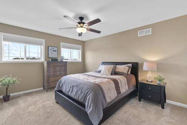 carpeted bedroom featuring baseboards, ceiling fan, and visible vents