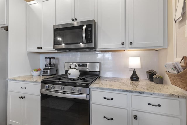 kitchen with white cabinetry, backsplash, and appliances with stainless steel finishes