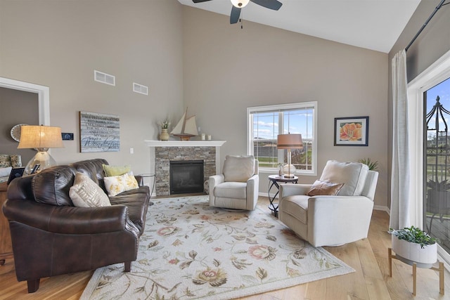 living area featuring a ceiling fan, visible vents, high vaulted ceiling, and wood finished floors