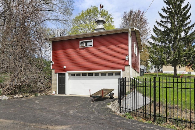N1453 Clover Rd, Genoa City, WI 53128 - view of side of home with fence, a yard, a garage, and aphalt driveway