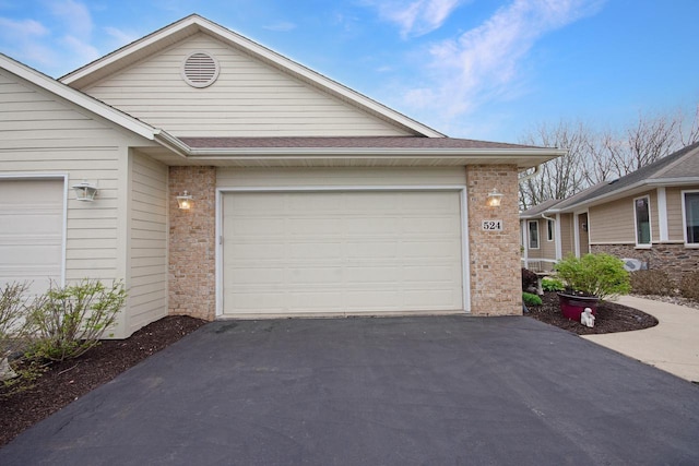 524 Tindalls Nest, Twin Lakes, WI 53181 - view of front of property with brick siding, a garage, aphalt driveway, and roof with shingles