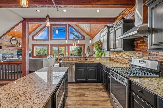 3024 Nagawicka Ave, Delafield, WI 53018 - kitchen featuring stainless steel appliances, wall chimney exhaust hood, wood finished floors, open floor plan, and light stone countertops