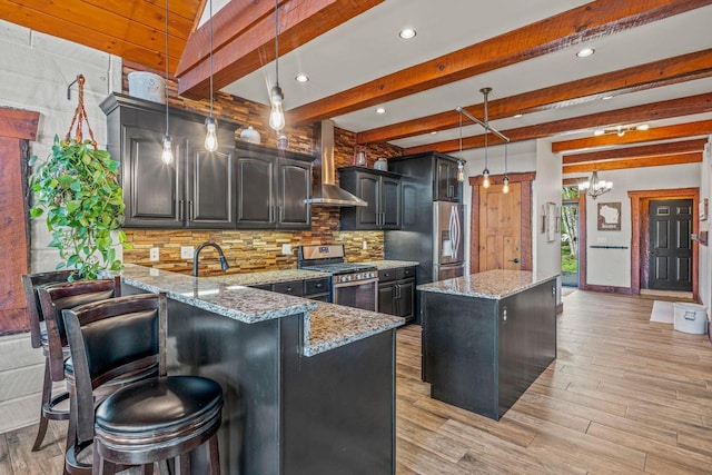 3024 Nagawicka Ave, Delafield, WI 53018 - kitchen with appliances with stainless steel finishes, wall chimney range hood, backsplash, light stone counters, and a kitchen island
