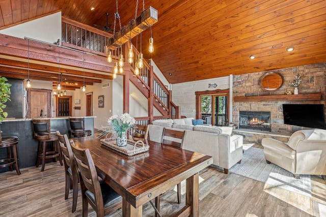 3024 Nagawicka Ave, Delafield, WI 53018 - dining space with wood ceiling, high vaulted ceiling, wood finished floors, stairs, and a stone fireplace