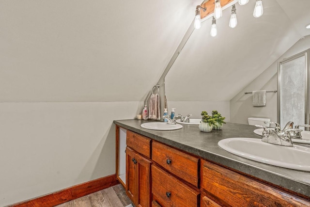 3024 Nagawicka Ave, Delafield, WI 53018 - full bath featuring vaulted ceiling, wood finished floors, double vanity, toilet, and baseboards