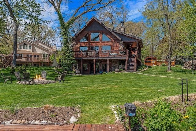 3024 Nagawicka Ave, Delafield, WI 53018 - rear view of house with a wooden deck, a fire pit, stairs, and a lawn