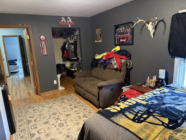 bedroom featuring a closet, a textured ceiling, and wood finished floors