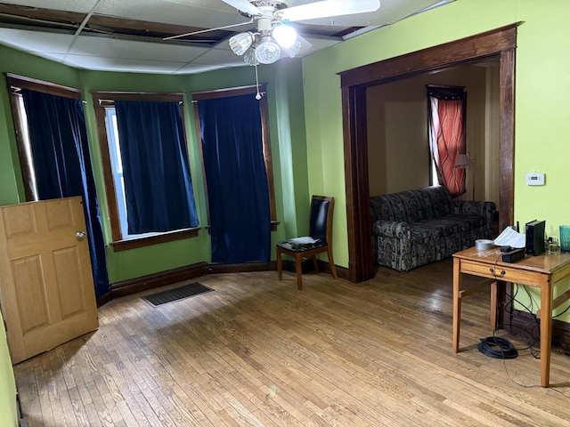 interior space featuring a ceiling fan, baseboards, visible vents, and hardwood / wood-style floors