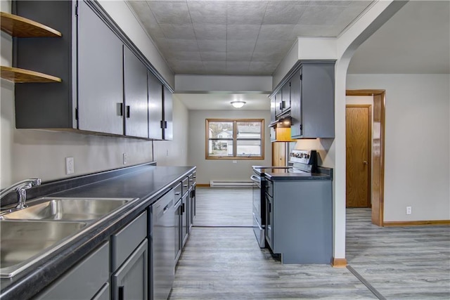 208 W Grand Ave, Chippewa Falls, WI 54729 - kitchen with dark countertops, appliances with stainless steel finishes, a sink, light wood finished floors, and under cabinet range hood