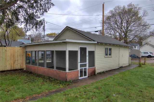208 W Grand Ave, Chippewa Falls, WI 54729 - back of property featuring a sunroom, a shingled roof, fence, and a yard