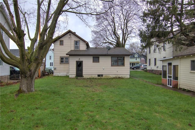 208 W Grand Ave, Chippewa Falls, WI 54729 - rear view of property featuring a shingled roof and a yard