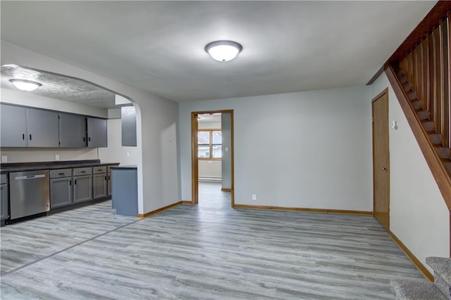 208 W Grand Ave, Chippewa Falls, WI 54729 - kitchen featuring gray cabinets, dark countertops, arched walkways, light wood-type flooring, and dishwasher