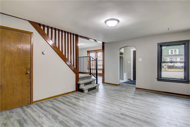 208 W Grand Ave, Chippewa Falls, WI 54729 - entrance foyer featuring stairway, arched walkways, baseboards, and light wood finished floors