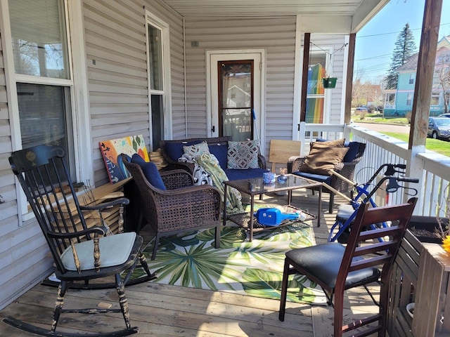 wooden terrace featuring covered porch and an outdoor hangout area