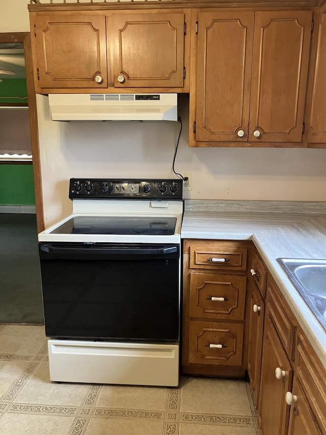 365 Jenkynsville Rd, Benton, WI 53803 - kitchen with electric stove, light tile patterned floors, under cabinet range hood, and light countertops