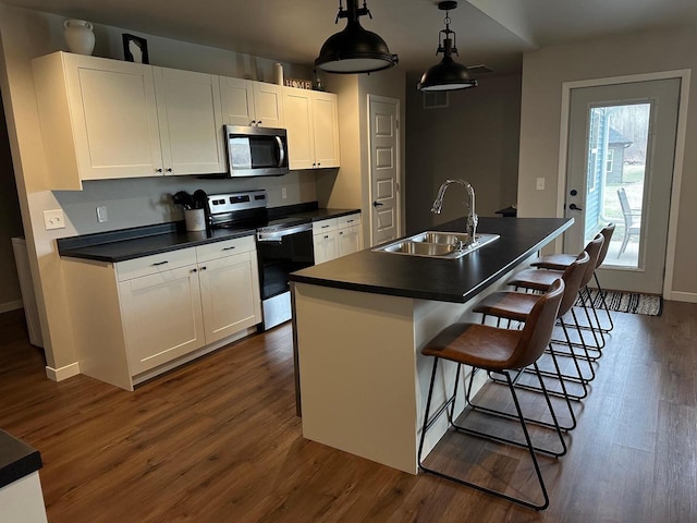 1817 Ridgewood Cir, Menomonie, WI 54751 - kitchen with appliances with stainless steel finishes, a sink, dark countertops, white cabinets, and dark wood-style flooring