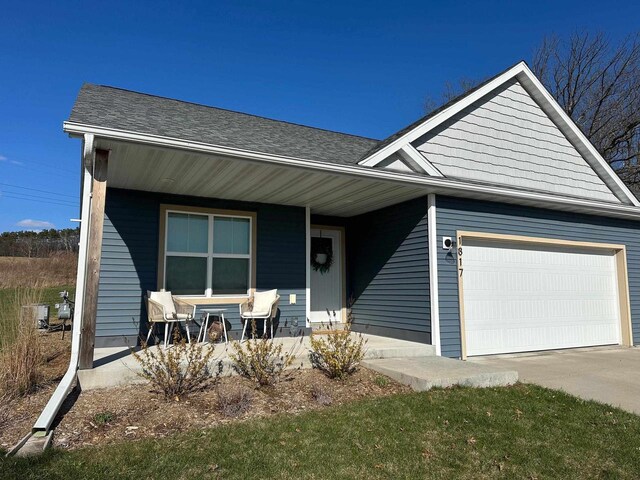 1817 Ridgewood Cir, Menomonie, WI 54751 - view of front of house featuring a garage, covered porch, driveway, and roof with shingles