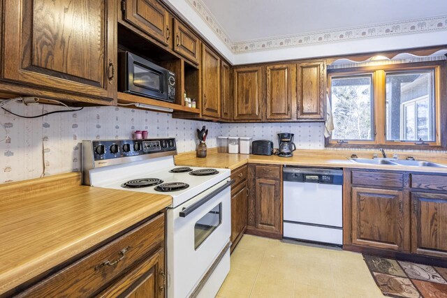 101224 25th St, Chetek, WI 54728 - kitchen with a sink, light countertops, wallpapered walls, and white appliances
