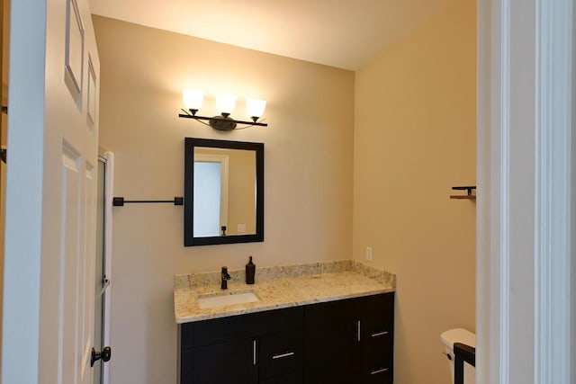 bathroom with vanity, toilet, and a notable chandelier