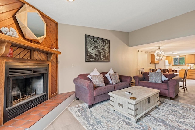 living room with a chandelier, wood finished floors, and a fireplace