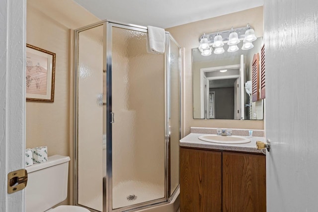 full bathroom with vanity, a stall shower, and toilet