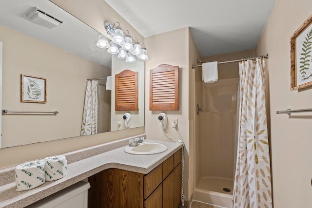 bathroom with vanity, visible vents, and a stall shower