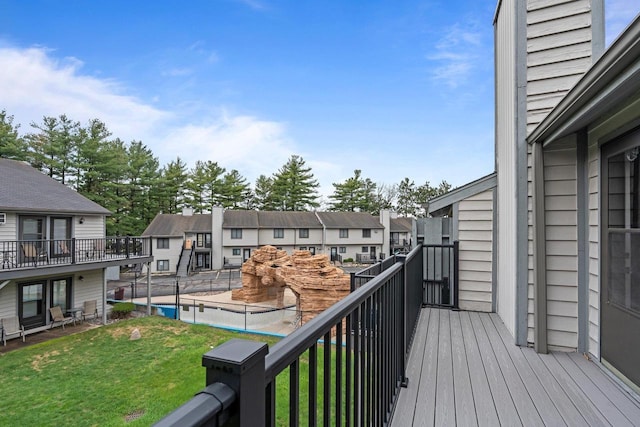wooden deck featuring a residential view and a lawn