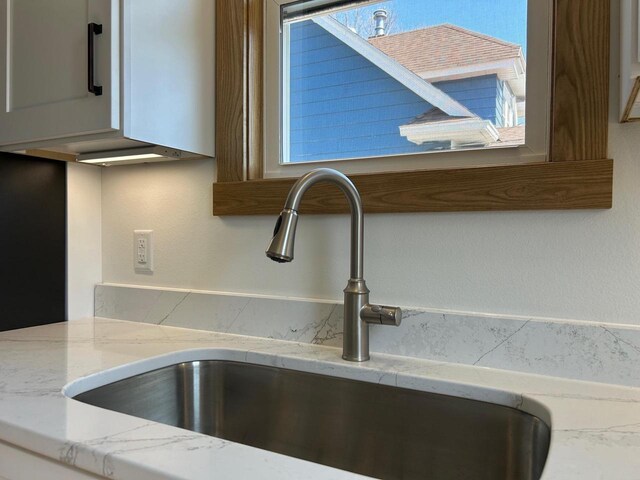 1019 Ellis Ave, Ashland, WI 54806 - room details featuring light stone countertops, decorative backsplash, and a sink