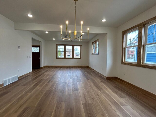 1019 Ellis Ave, Ashland, WI 54806 - unfurnished dining area featuring visible vents, wood finished floors, baseboards, a chandelier, and recessed lighting