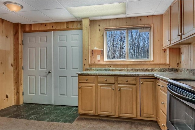 kitchen with light countertops, range with electric cooktop, a drop ceiling, and wooden walls