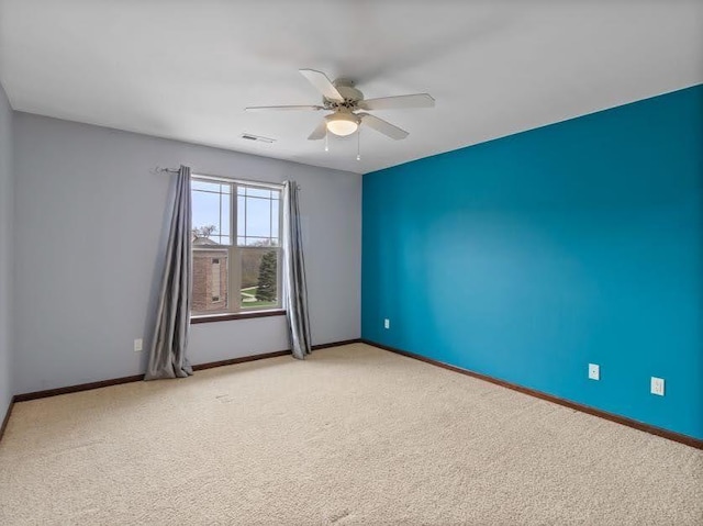unfurnished room featuring carpet flooring, a ceiling fan, and baseboards