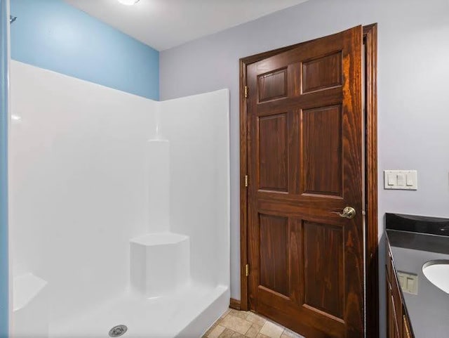 full bath featuring vanity and a shower