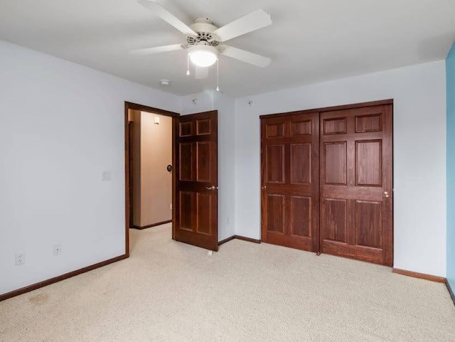 unfurnished bedroom featuring baseboards and light carpet