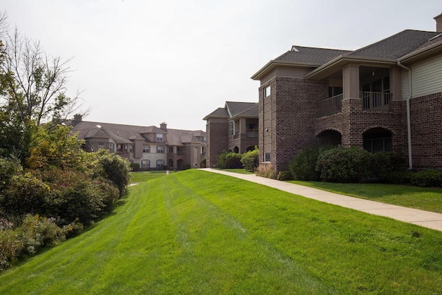 view of property's community featuring a lawn and a residential view