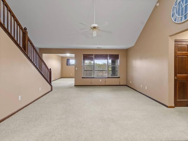 unfurnished living room with baseboards, a ceiling fan, light carpet, and stairway