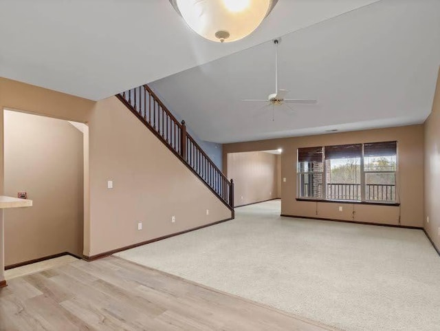 unfurnished living room featuring baseboards, a ceiling fan, and wood finished floors
