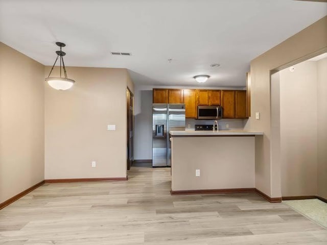 kitchen with visible vents, baseboards, brown cabinets, light wood-style flooring, and stainless steel appliances