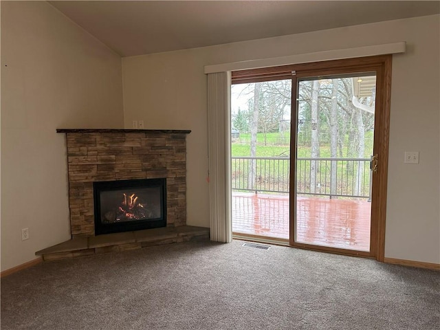 unfurnished living room with carpet floors, visible vents, vaulted ceiling, and a fireplace