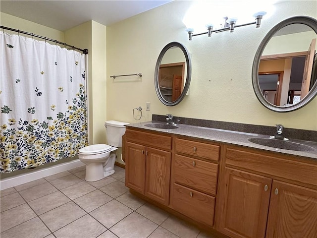 bathroom featuring double vanity, a sink, tile patterned floors, and toilet