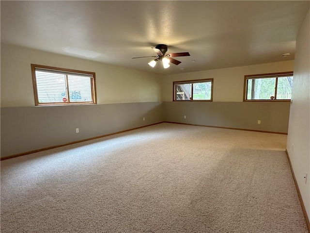 empty room featuring baseboards, a ceiling fan, and carpet