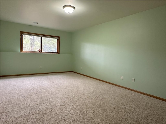 spare room featuring carpet flooring and baseboards
