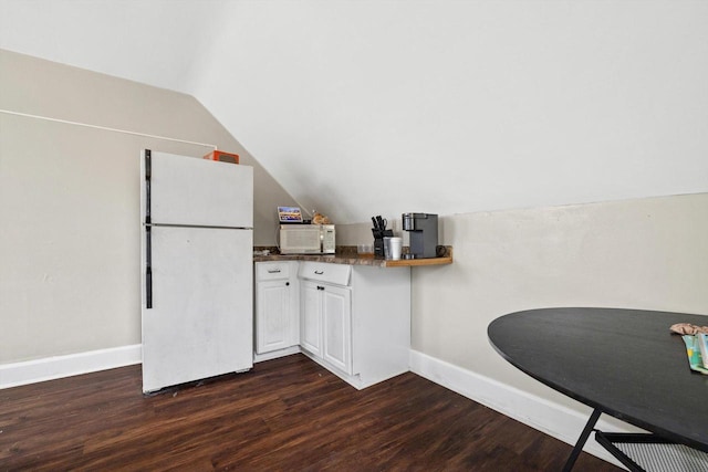kitchen featuring vaulted ceiling, baseboards, dark wood-style floors, white appliances, and white cabinetry