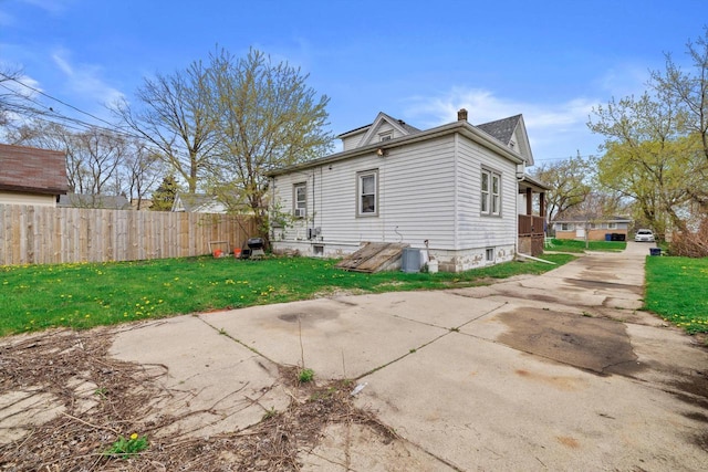 rear view of property with fence, a chimney, and a yard