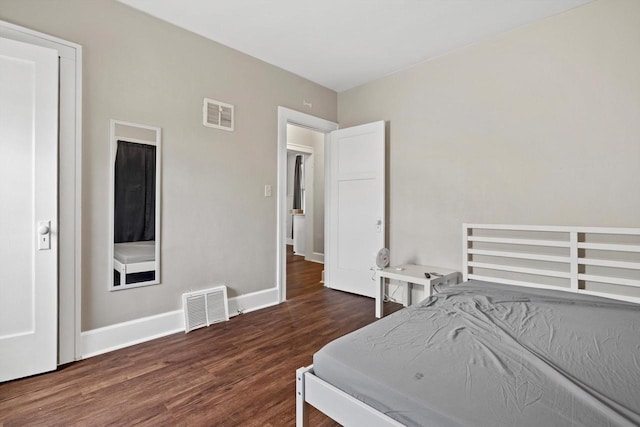 bedroom featuring visible vents, baseboards, and wood finished floors