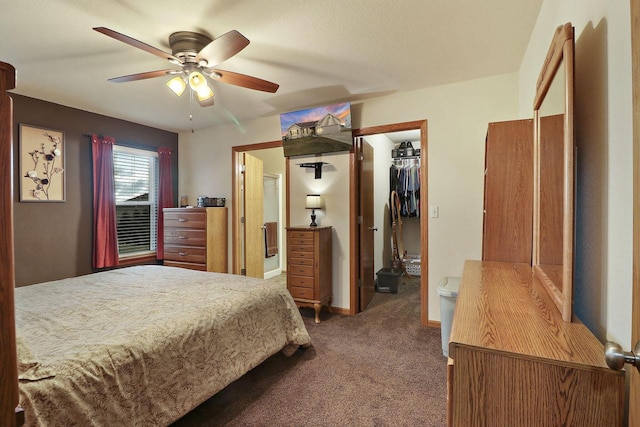 bedroom with carpet floors, baseboards, a ceiling fan, and a walk in closet