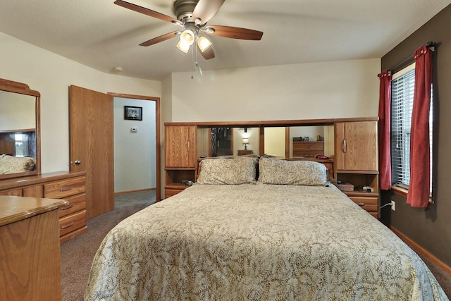 bedroom with dark carpet, a ceiling fan, and baseboards